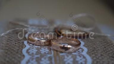两个<strong>结婚戒</strong>指放在桌子上，放在漂亮的布料上，带着一颗心